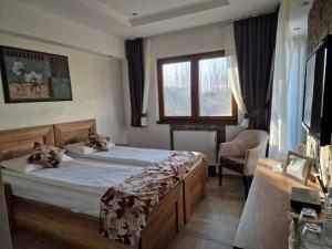 a bedroom with a bed and a chair and a window at Bački dvor 