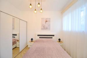 - une chambre blanche avec un lit et un miroir dans l'établissement Old Kotor apartment, à Kotor