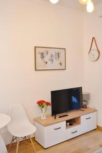 - un salon avec une télévision et une chaise blanche dans l'établissement Old Kotor apartment, à Kotor