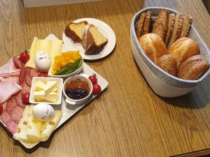 une table avec des assiettes de nourriture et un panier de pain dans l'établissement Biohof Obereibensteiner, à Kaltenberg