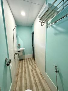 y baño con aseo, lavabo y espejo. en Như Mây Homestay en Phu Quoc