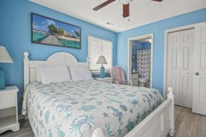 a bedroom with a white bed and a blue wall at Lighthouse II Unit 6 in Myrtle Beach