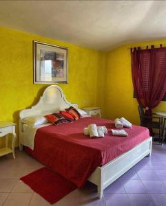1 dormitorio con 1 cama grande con sábanas rojas en Hotel La Ciaccia en Valledoria