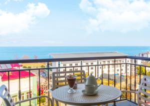 una mesa con una bebida en un balcón con vistas al océano en NEHİR OTEL, en Pelitli