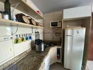 a small kitchen with a refrigerator and a microwave at Casa na praia de Itajuba in Barra Velha