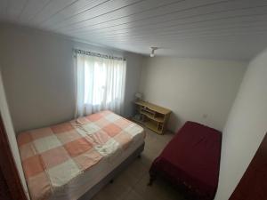 a small bedroom with a bed and a window at Casa na praia de Itajuba in Barra Velha