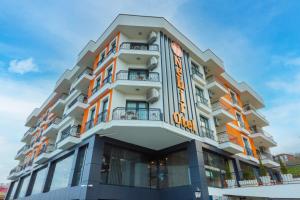 a tall building with an orange sign on it at NEHİR OTEL in Pelitli