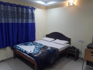 een slaapkamer met een bed met een blauw gordijn bij Blue Moon Residency in Mysore