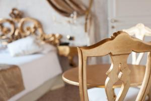 a wooden chair in front of a bedroom with a bed at Villa Gasparini in Dolo