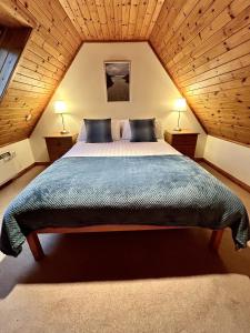 a bedroom with a large bed in a attic at Fern Cottage in Lairg