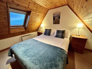 a bedroom with a large bed in a wooden cabin at Fern Cottage in Lairg