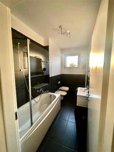 a bathroom with a tub and a toilet and a sink at Lake Como view Apartment in Como