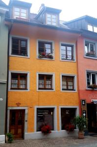 Un bâtiment orange et blanc avec des fleurs dans les fenêtres dans l'établissement FeWo Sonne, à Constance