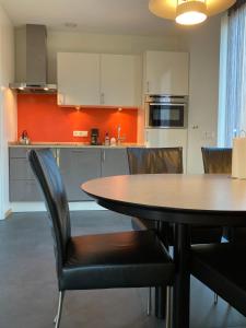 Het Klavertje في Laren: مطبخ مع طاولة وكراسي في غرفة