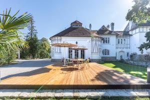 una casa con terrazza in legno con tavolo e ombrellone di Schloss Schönau a Schönau an der Triesting