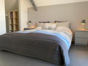 Het Klavertje في Laren: سرير كبير في غرفة نوم مع مواقف ليلتين