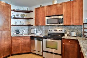 a kitchen with stainless steel appliances and wooden cabinets at Emerald 1111 in Galveston