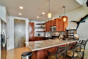 a kitchen with wooden cabinets and a island with bar stools at Emerald 1111 in Galveston
