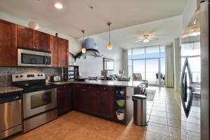 a kitchen with wooden cabinets and a stove top oven at Emerald 1111 in Galveston +31 photos