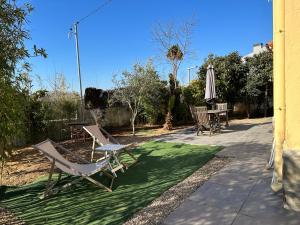 een patio met een tafel en stoelen en een parasol bij Tu Casa en Barcelona in Sant Cugat del Vallès