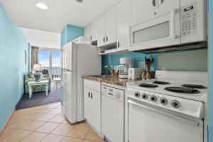 uma cozinha com electrodomésticos brancos e paredes azuis em Avista Resort 1503 condo em Myrtle Beach