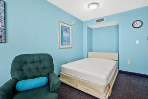 um quarto azul com uma cama e uma cadeira em Avista Resort 1503 condo em Myrtle Beach