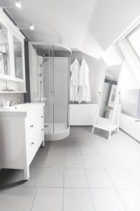 a white bathroom with a shower and a sink at B&B BedStarLine in Antwerp