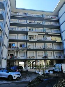 ein Apartmenthaus mit Autos auf einem Parkplatz in der Unterkunft Appartamento vista mare in Lido di Jesolo