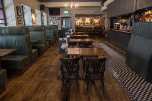un restaurante con mesas de madera y cabinas verdes en The Pride of Paddington en Londres