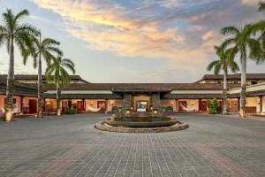 un edificio con una fuente en un patio con palmeras en JW Marriott Guanacaste Resort & Spa en Tamarindo