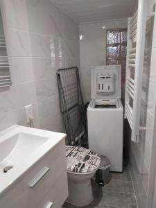 a white bathroom with a toilet and a sink at La maison D'Orée in Polignac