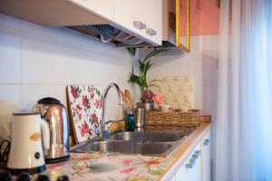 una cucina con lavandino e piano di lavoro di BIBI BOUTIQUE AREZZO Appartamento Rosafragola - Verdeconiglio ad Arezzo