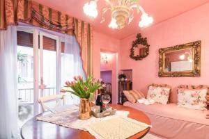 ein rosafarbenes Wohnzimmer mit einem Tisch und einem Sofa in der Unterkunft BIBI BOUTIQUE AREZZO Appartamento Rosafragola - Verdeconiglio in Arezzo