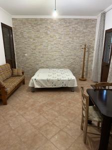 1 dormitorio con cama y pared de ladrillo en Villetta Forestaforte, en Leuca