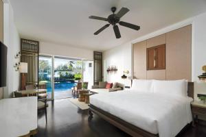 カオラックにあるJW Marriott Khao Lak Resort and Spaのベッドルーム(大型ベッド1台付)、リビングルームが備わります。