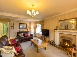 a living room with a couch and a fireplace at Vicarsford Farmhouse with Hot Tub in Leuchars