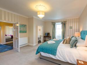 1 dormitorio con 1 cama grande con manta azul en Vicarsford Farmhouse with Hot Tub, en Leuchars