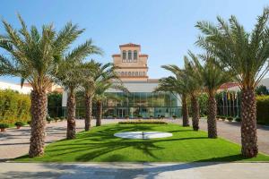 een resort met palmbomen voor een gebouw bij Le Meridien Ra Beach Hotel and Spa in El Vendrell