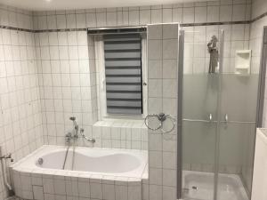 baño con bañera y ducha con puerta de cristal en Hotel Eintracht en Mittweida