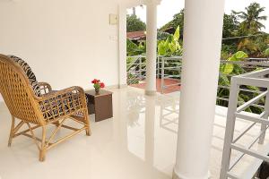 a wicker chair sitting on top of a balcony at Aleenas homestay in Cochin