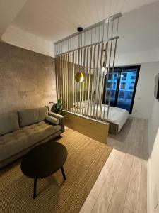 een woonkamer met een bank en een bed bij Urban Flats in Boekarest