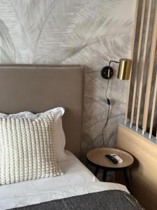 a bedroom with a bed with a lamp and a side table at Urban Flats in Bucharest