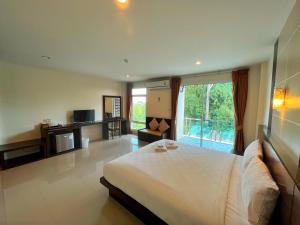 a bedroom with a large bed and a large window at Peak Boutique City Hotel Krabi in Krabi town