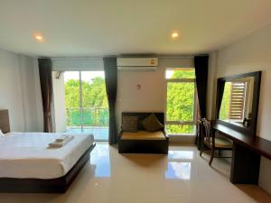 a bedroom with a bed and a couch and a window at Peak Boutique City Hotel Krabi in Krabi