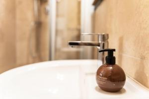 un dispenser di sapone posto sopra un lavandino del bagno di BIBI BOUTIQUE AREZZO Cartazucchero - Cioccolato ad Arezzo