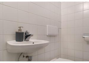 Baño blanco con lavabo y aseo en Homely 3BR Apt.- Perfect for families and groups en Viena
