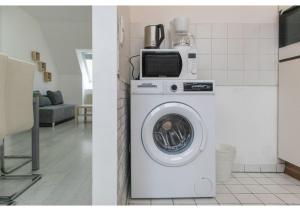 a washing machine with a microwave on top of it at Homely 3BR Apt.- Perfect for families and groups in Vienna