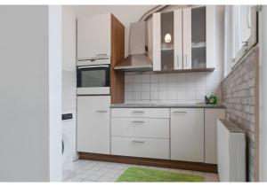 cocina con armarios blancos y alfombra verde en Homely 3BR Apt.- Perfect for families and groups en Viena