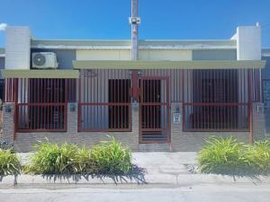 un edificio con puertas rojas y plantas delante de él en 1 - Affordable Family Place to Stay In Cabanatuan, en Cabanatúan