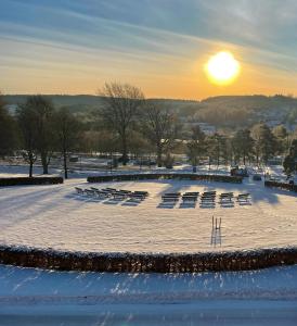 a snow covered amphitheater with chairs and the sunset at Kinna Bed & Breakfast in Kinna